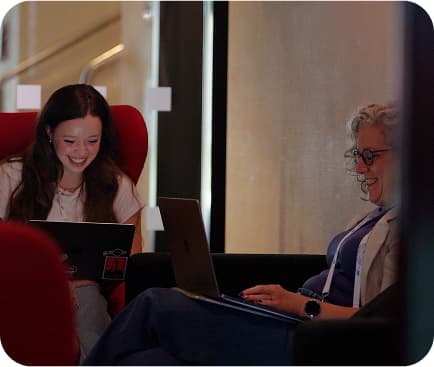 Team members sitting with computers and smiling
